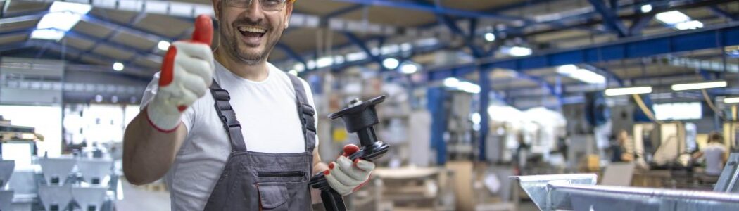 portrait-factory-worker-protective-equipment-holding-thumbs-up-production-hall-min